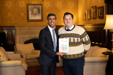 Louie showing the Prime Minister the winning Christmas card design